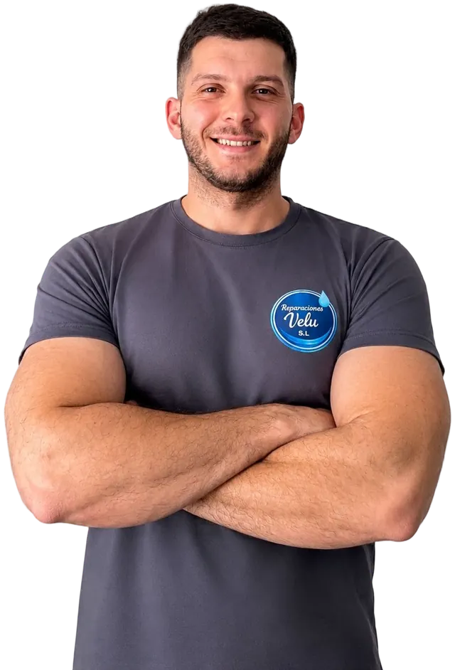 Fontanero de Reparaciones Velu sonriendo, con la camiseta de la empresa y los brazos cruzados